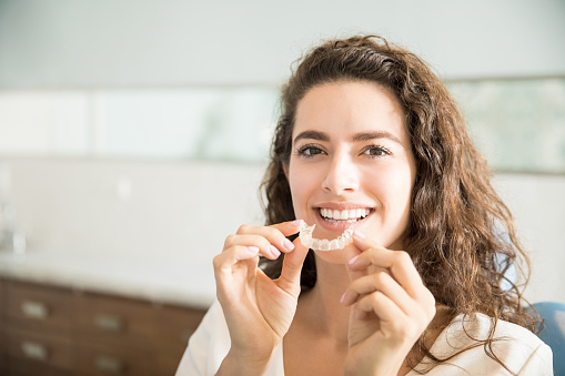 Patient holding Invisalign® Clear Aligners at Watermark Dentistry in Normandy Park, WA